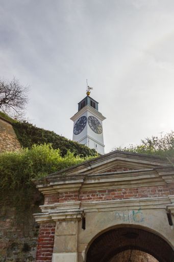 A vertical shot of a tower with a clock in Serbia under the blue sky
