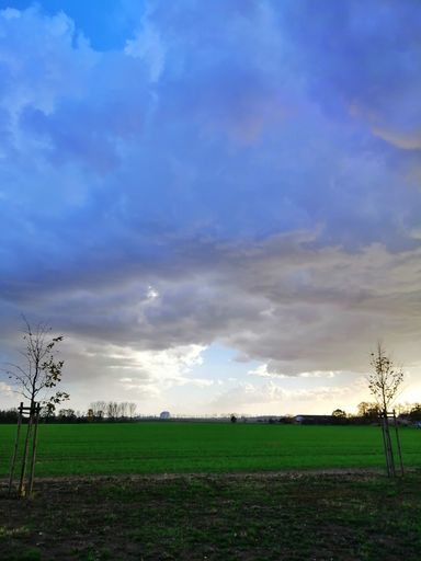 A vertical picture of a field under a cloudy sky during the evening in Stargard in Poland
