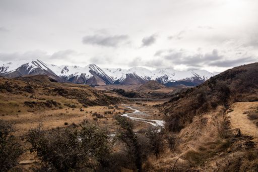 A scenic landscape with snow-capped mountains in the background, Cave Stream Canterbury reserve, South Island, New Zealand