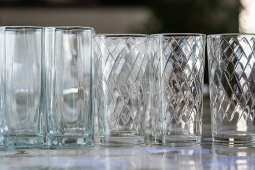 Empty clean glass goblets stand on table against dark background