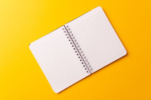 A top view of an open journal isolated on a yellow background