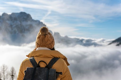The female hiker looking at amazing mountains at Monte Lussari in Julian alps in Italy