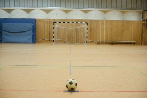 A closeup shot of a yellow and red ball in the sports hall