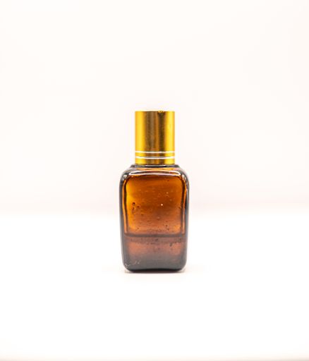 A closeup of a bronze-colored bottle of female perfume with a golden cap isolated on a white background
