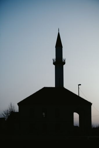 A vertical shot of the silhouette of village landscape during a sunrise in summer morning