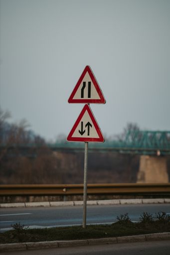 A vertical shot of two traffic signs on the street