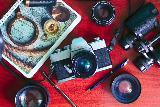 A flat lay of photographic equipment on red background