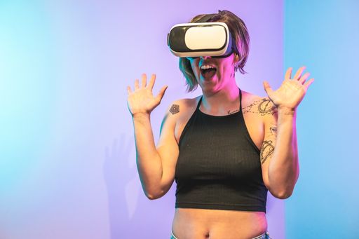 A cool Spanish girl wearing virtual reality glasses with a frightened face and gesture in a neon lights room