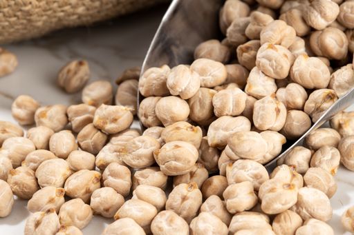 Close up of Chickpeas on scoop on White marble Background. Cicer arietinum