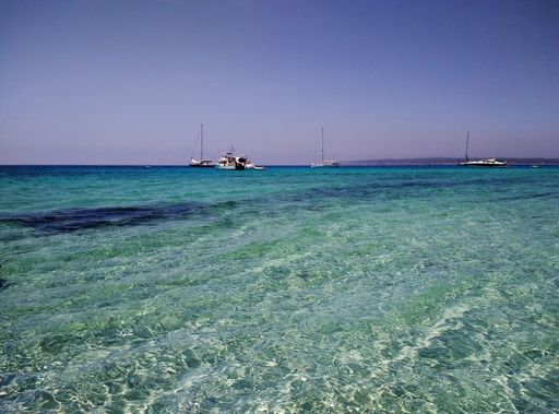 A beautiful shot of the water surface and boats floating in back in Formentera, Spain