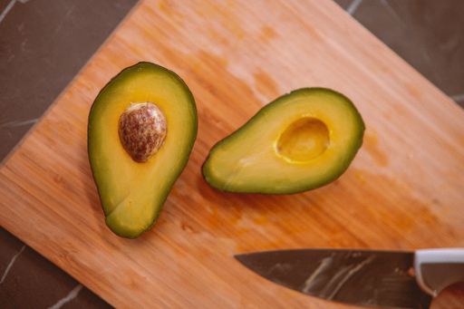 A top view of a cut avocado on the cutting wooden board