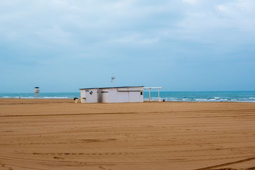 A closeup shot of a sandy seashore with the sea in the background