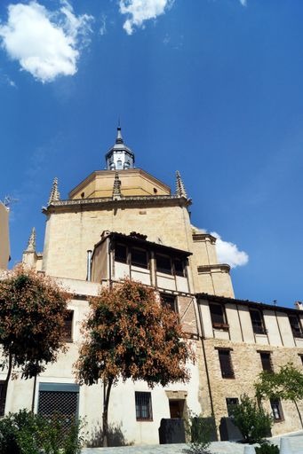 A bottom view shot of a tall tower with a steel green dome in Segovia, Spain