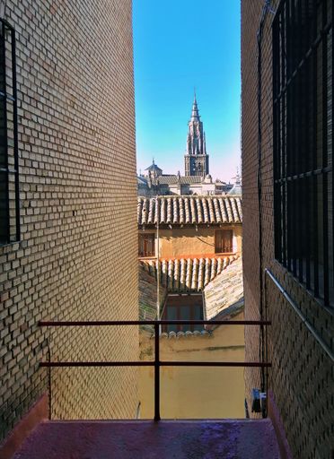 A vertical shot from between two building on the tower of Alcázar de Toledo in Toledo, Spain