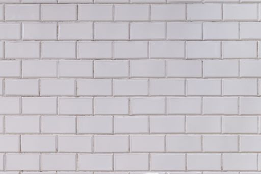 A white textured old porcelain wall tile on the station of Budapest metro line