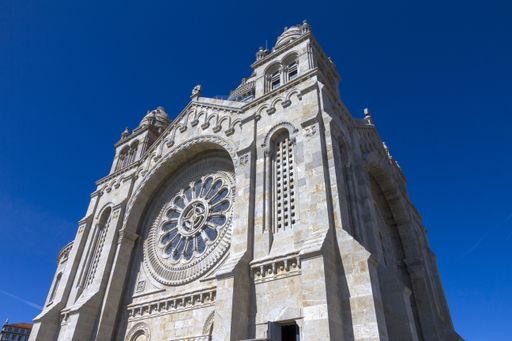 a low angle shot of a cathedral Santuario de Santa Luzia in Portugal on the blue sky background