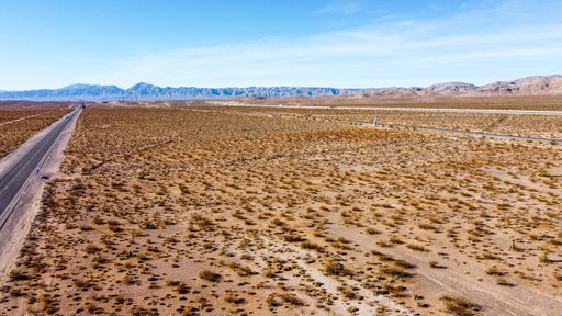 An aerial shot of desert road with Mountains on the horizon in Nevada