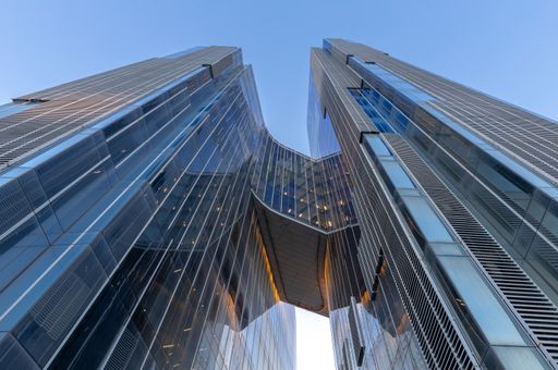 A bottom view shot of two buildings connected with a bridge