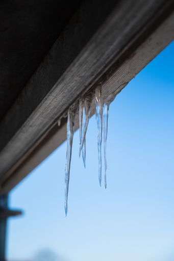 A vertical shot of icicles hanging from the building roof