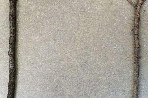 A top view of twigs laid out on the right and left sides of the asphalt background with copy space in the center