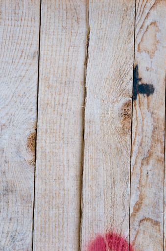 A top view of wooden planks with spots on the surface