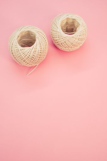 A top view of two knitting balls isolated in the pink background with copy space in the bottom