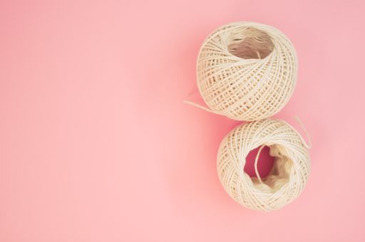 A top view of two knitting balls isolated on the right side of the pink background with a copy space
