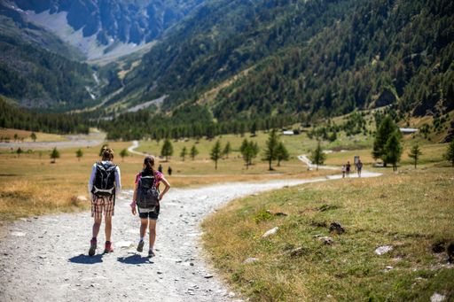 A pathway towards the mountains with two females walking