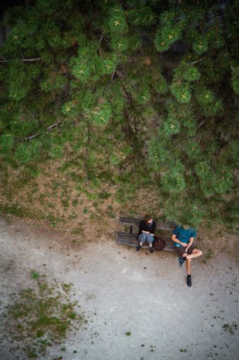 Two people sitting on a bench in a park