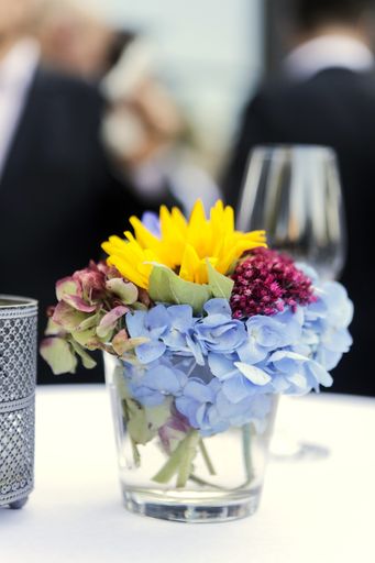 A selective focus shot of a cup filled with colorful flowers