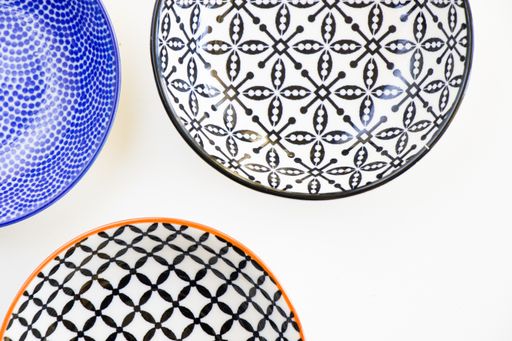 A top view of blue and black-white empty patterned bowls isolated on the white background - geometry, design