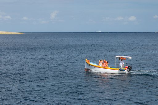 A beautiful shot of people on a small white boat in the middle of the sea