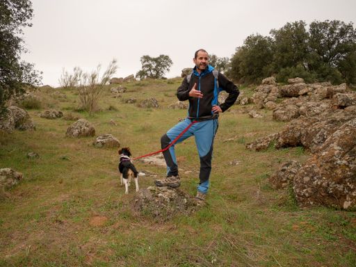 A male hiker walking with his beagle dog
