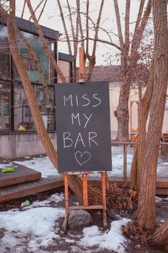 A vertical shot of a board with the "Miss my bar" inscription outdoor