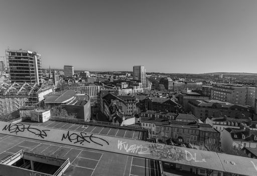 Monochrome photo of Bristol's skyline from the top floor of a multistory parking lot.
