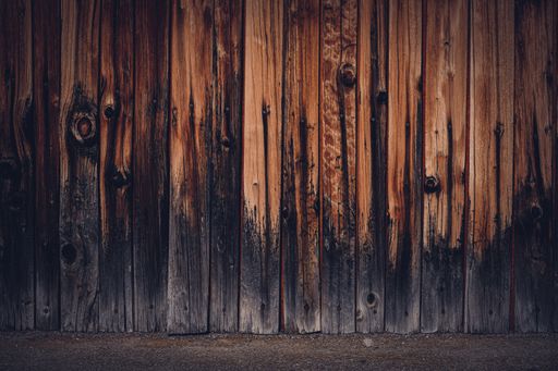 A closeup shot of a wood fence with charred base