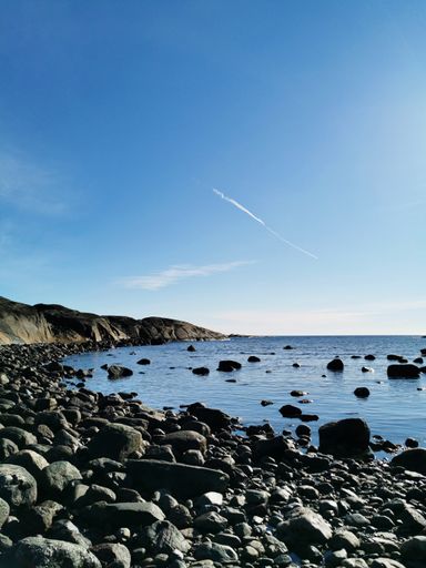 A beautiful shot of the river from a pebble beach of Rakke (Larvik, Norway) on a sunny day