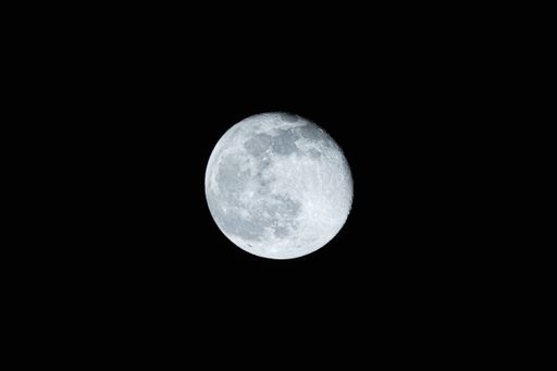 A round bright white moon in a black sky