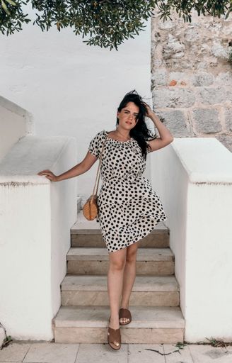 A vertical shot of a caucasian brunette female posing on the stairs with white railings