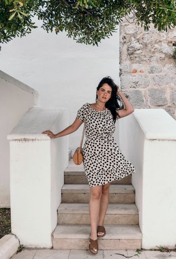 A vertical shot of a caucasian brunette female posing on the stairs with white railings