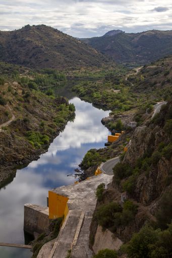 A top view shot of a hydropower electric dam surrounded by mountains