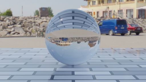 A selective focus shot of a reverse reflective glass ball in the street, with cars, buildings, and rocks in the background