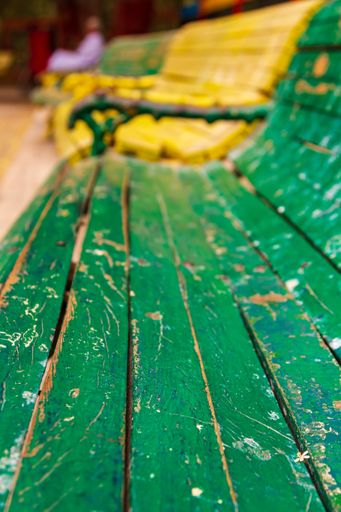 A selective focus shot of an old colorful wooden bench