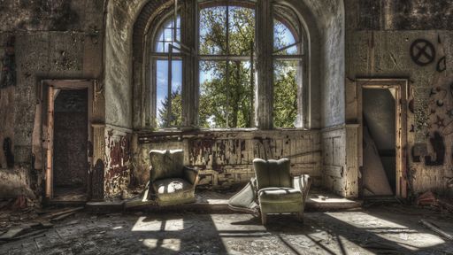 The damaged armchairs in an abandoned ruined room