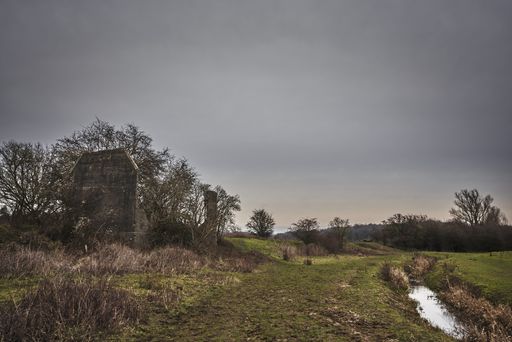 The remains of an old destroyed house under a cloudy sky