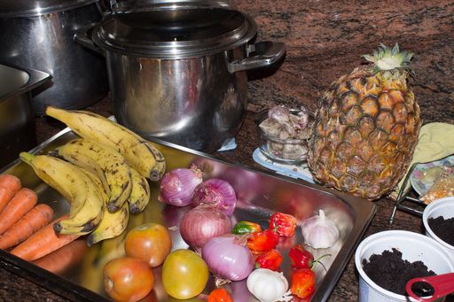 A high angle shot of fresh fruits and vegetables on a metal tray in a kitche