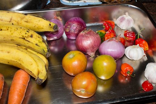A high angle shot of fresh fruits and vegetables in a metal tray on a table
