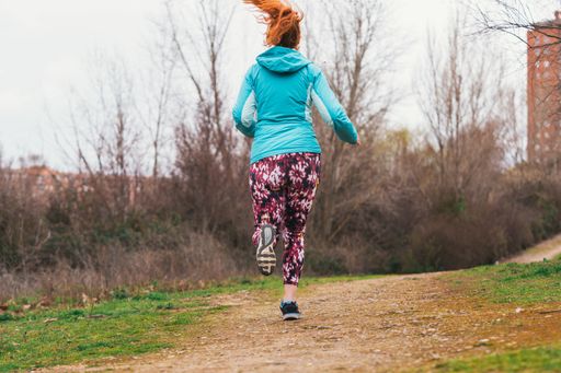 A closeup shot of a sporty red-haired Caucasian female doing exercises outdoor