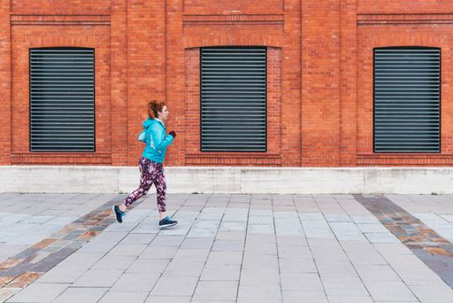 A closeup shot of a sporty red-haired Caucasian female doing exercises outdoor