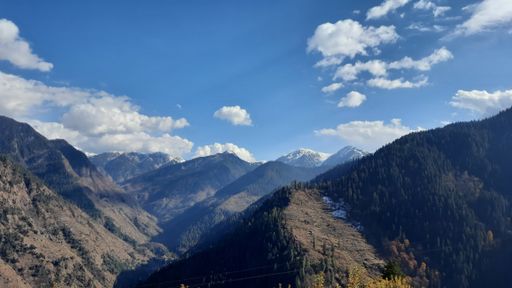 A beautiful shot of the hill station with trees and a sunny but partly cloudy sky.
